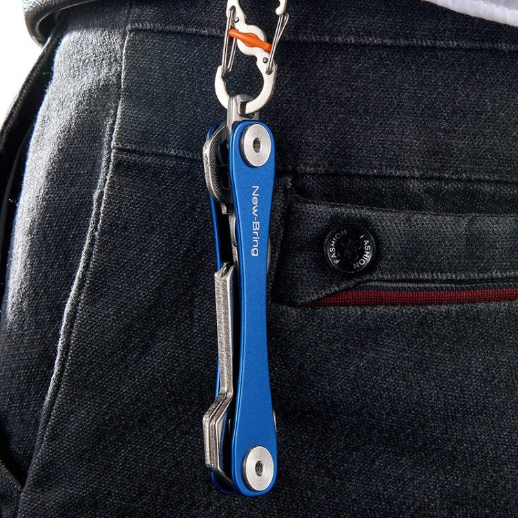 Blue metal emergency tool keychain clipped to a jeans pocket with key tools extended