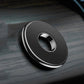 Round magnetic car phone holder on dashboard, black with silver trim