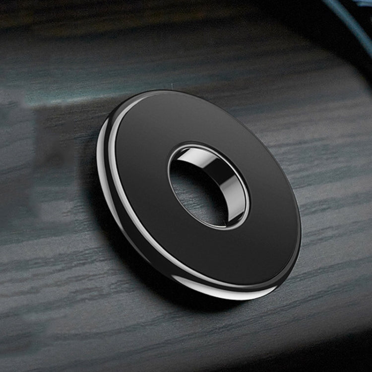 Round magnetic car phone holder on dashboard, black with silver trim