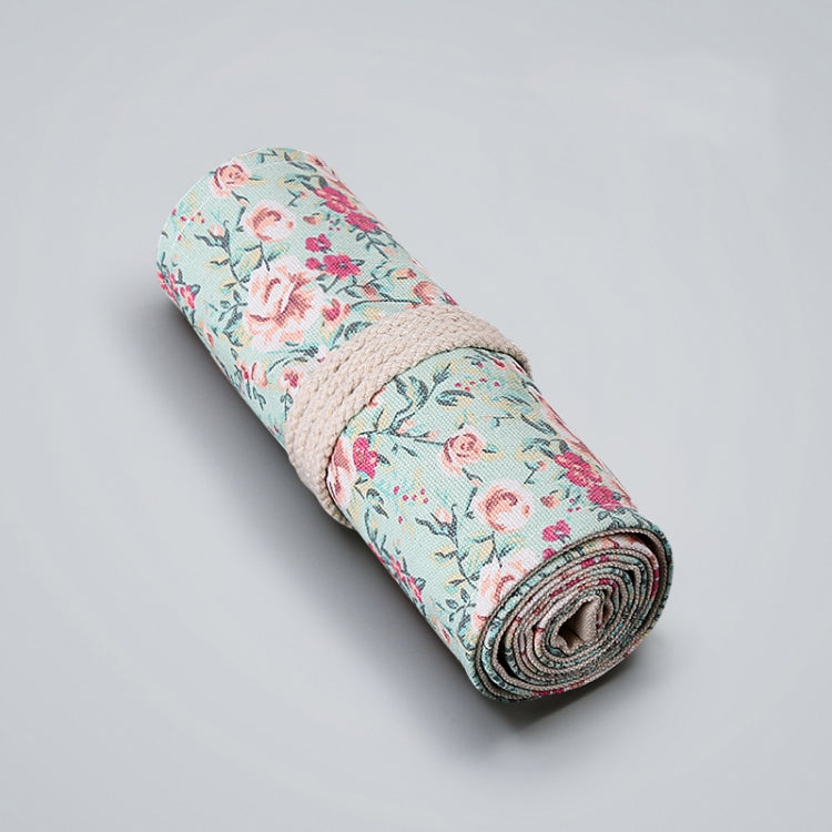 Floral canvas pen roll pouch, rolled with beige tie; pastel blue and pink floral.