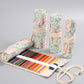 Floral canvas pen roll with colored pencils, rolled sleeves and beige drawstring.