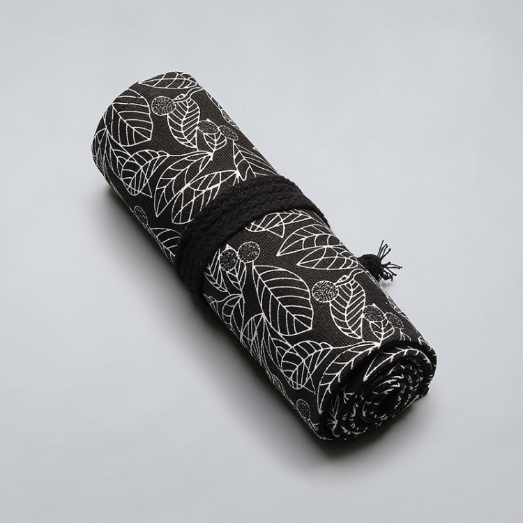 Rolled black canvas pen bag with white leaf pattern and tassel tie on the side