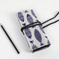 Close-up of tied canvas pencil roll with blue-and-white fish pattern and black cord