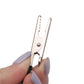 Motorcycle circuit tester alligator clip held in hand, silver jaws with coiled lead