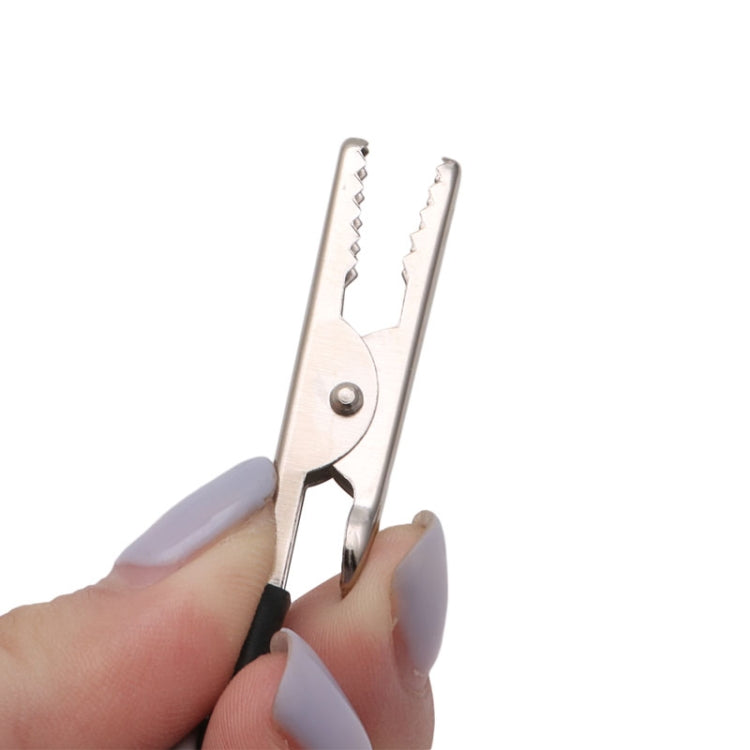 Motorcycle circuit tester alligator clip held in hand, silver jaws with coiled lead