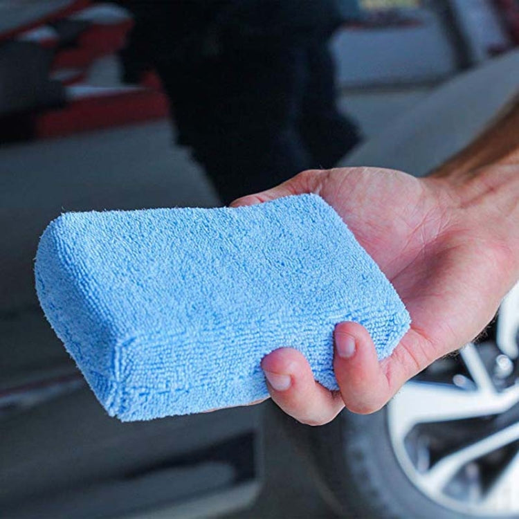 Blue microfiber sponge cloth, rectangular, held in hand for car washing and polishing