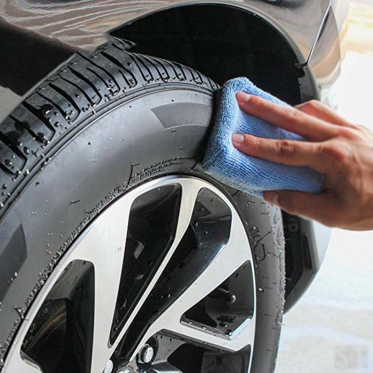 Blue microfiber cloth scrubbing car wheel tread