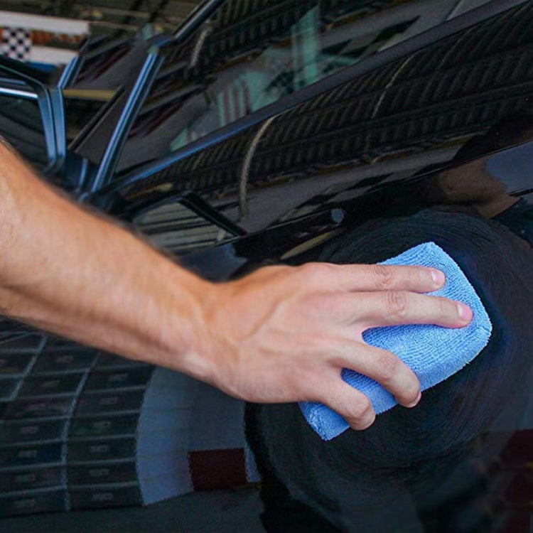 Blue microfiber sponge cloth wiping dark car body panel