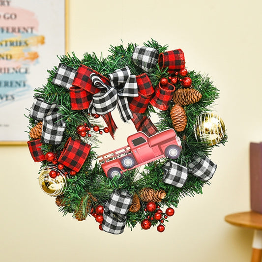 Christmas wreath door decoration with green pine, red berries, plaid ribbons, pinecones, and truck ornament