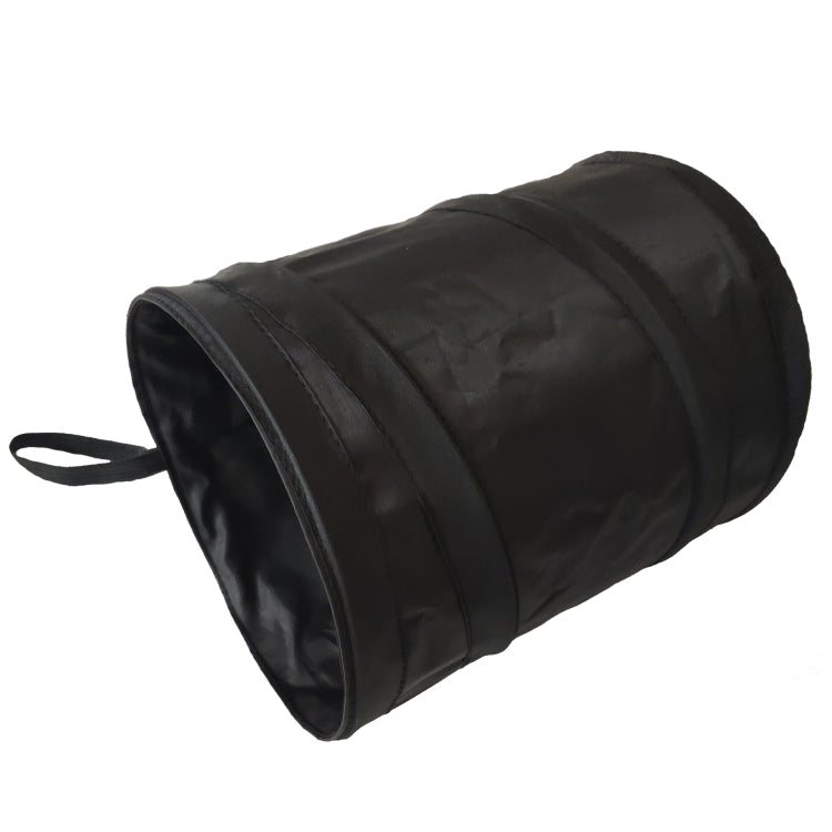 Foldable black trash bin with loop handle, cylindrical storage shape.