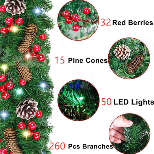 Green Christmas garland close-up with red berries, pinecones, and LED light strands