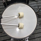 Drum hammers striking a kick drum head; felt mallet heads on metal shafts