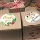 Floral 'thank you' round stickers on gift boxes, with greenery and rose accents