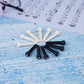 Assorted guitar string nails in white and black with plastic conical heads on blue paper
