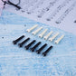 White and black guitar string nails with plastic conical heads arranged on blue paper