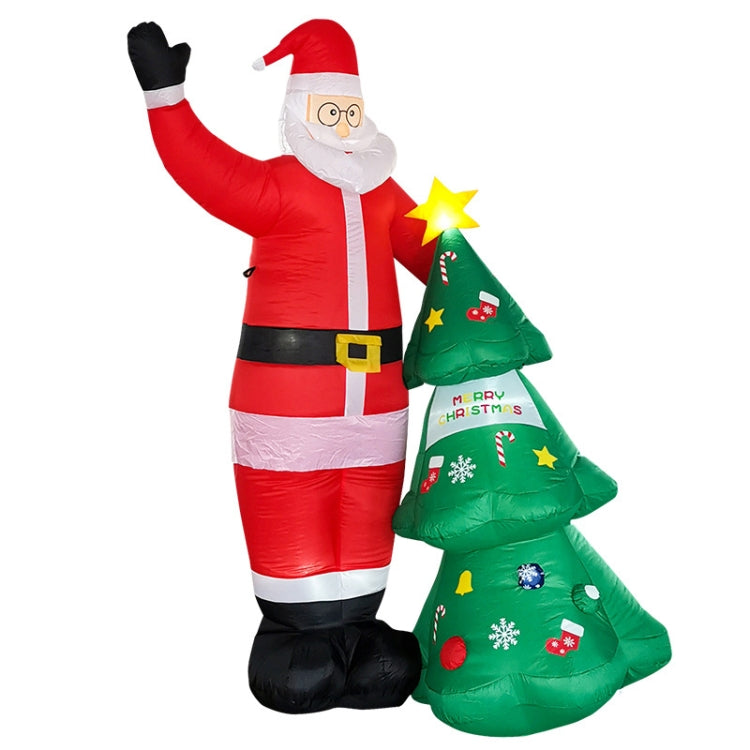 Inflatable Santa Claus with LED lights, beside a lit Christmas tree and star