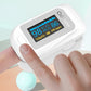 White finger pulse oximeter held in hand, showing SpO2 and PR bpm on screen