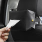 Black car tissue box holder attached to seat; hand pulls white tissues from front slot