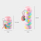 Collapsible silicone travel cup with rainbow folds, pink lid, carabiner, about 22 cm tall