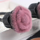 Close-up loose powder makeup brush with soft magenta bristles and black handle