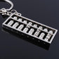 Small abacus key ring charm with silver bead rows on black base, angled view