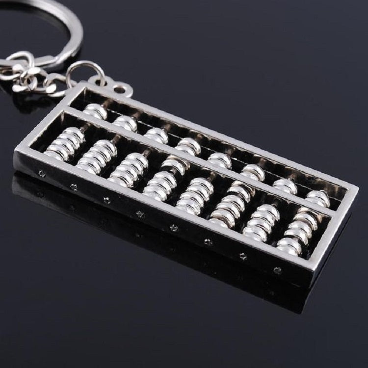 Small abacus key ring charm with silver bead rows on black base, angled view