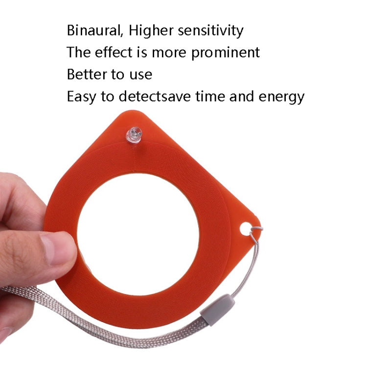 Hand holding red anti-theft induction coil detector with lanyard cord and front ring