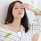 Air purifier hanging on a silver chain around a person’s neck, white body with rose-gold trim
