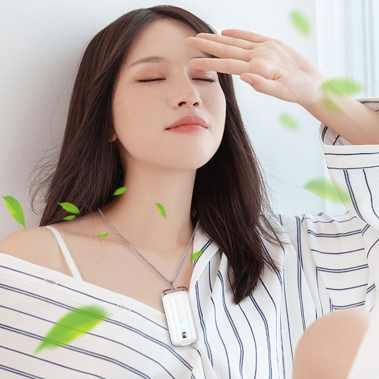 Air purifier hanging on a silver chain around a person’s neck, white body with rose-gold trim