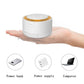 White cylindrical white-noise device held in a hand, warm orange top ring and buttons
