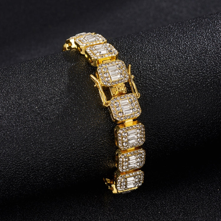 Gold-tone tennis bracelet close-up with square rhinestone blocks and hinge.
