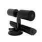 Black sit-up aid with two suction bases, foam rollers, and ankle supports