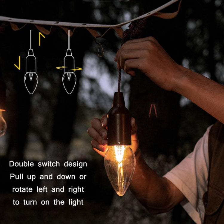 Hand pulling a brown pull-switch camping string light bulb to turn it on