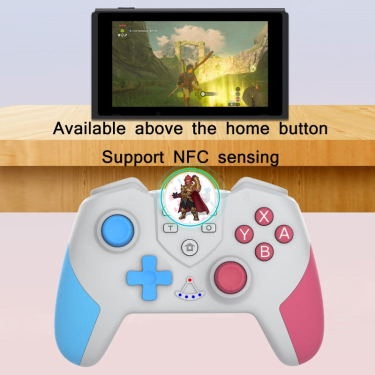 Hand holding white wireless game controller with blue D-pad and pink buttons, NFC