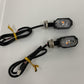 Pair of LED motorcycle turn signal lights with black octagon housings, amber lenses, wiring