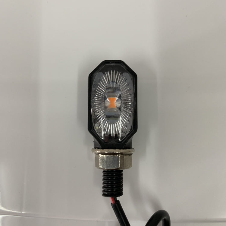 Single LED motorcycle turn signal lamp with amber lens, black octagon housing, red wire lead