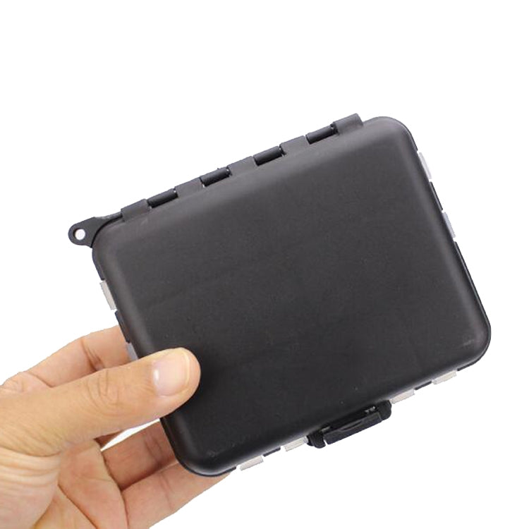 Closed black fishing tackle case for hook accessories held in a hand