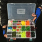 Fishing bait hook lure set in tackle box held in hands, assorted lures