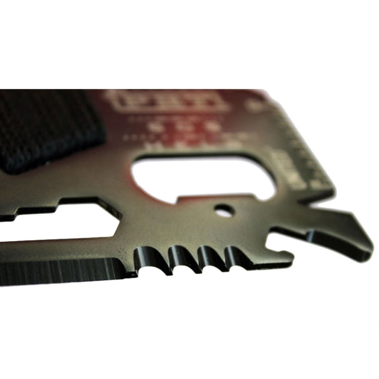 Close-up of dark survival tool card edge with serrated blade section