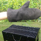 Gray heat-insulating leather BBQ glove resting on arm near grill