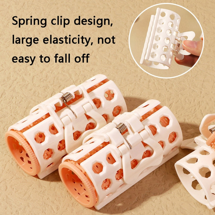 White lazy curlers with orange rollers and spring clip style ends