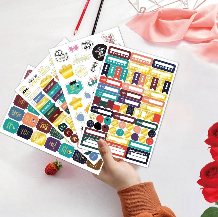 Colorful planner sticker sheets with icons, held in hand
