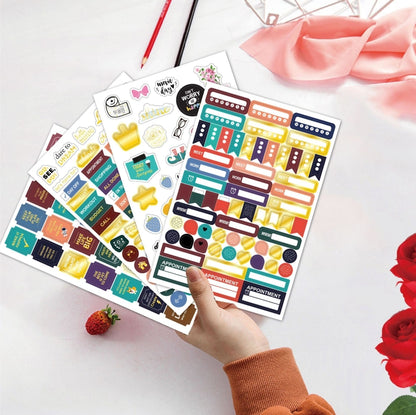 Colorful planner sticker sheets with icons, held in hand