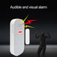 White door alarm with speaker grille and red visual indicator light, remote nearby.