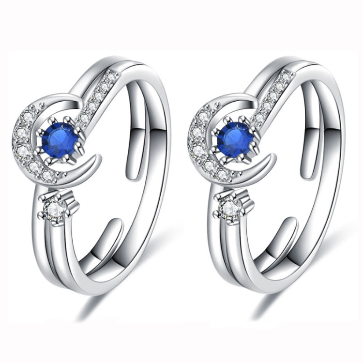 Open silver-tone ring set with star-and-moon design, blue center stone and clear accents
