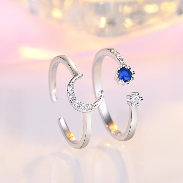 Two open silver rings with blue oval center stones and clear crystal sparkle, curved bands