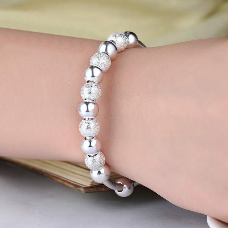 Silver-tone beaded bracelet on wrist with glitter round beads and ball links