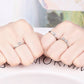 Four-leaf clover crystal rings on hands; silver open adjustable band style