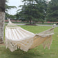 Double white canvas hammock with braided net seat and long fringe tassels.
