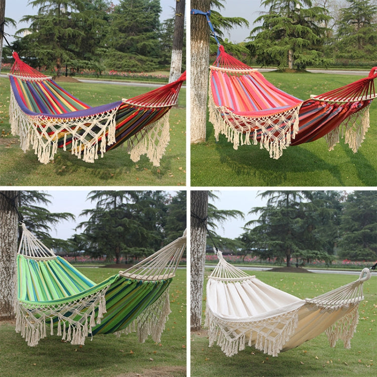 Double hammock with striped fabric, cream macrame net, and long tassel fringe.